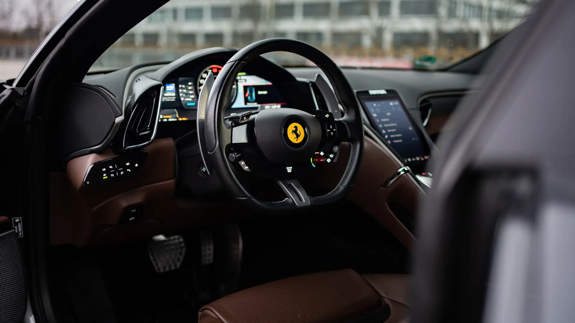 The steering wheel and interior of a Ferrari Roma.